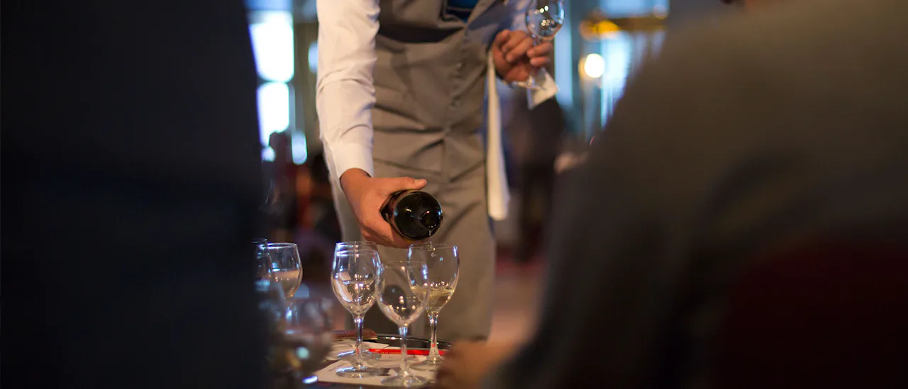 Waiter serving wine