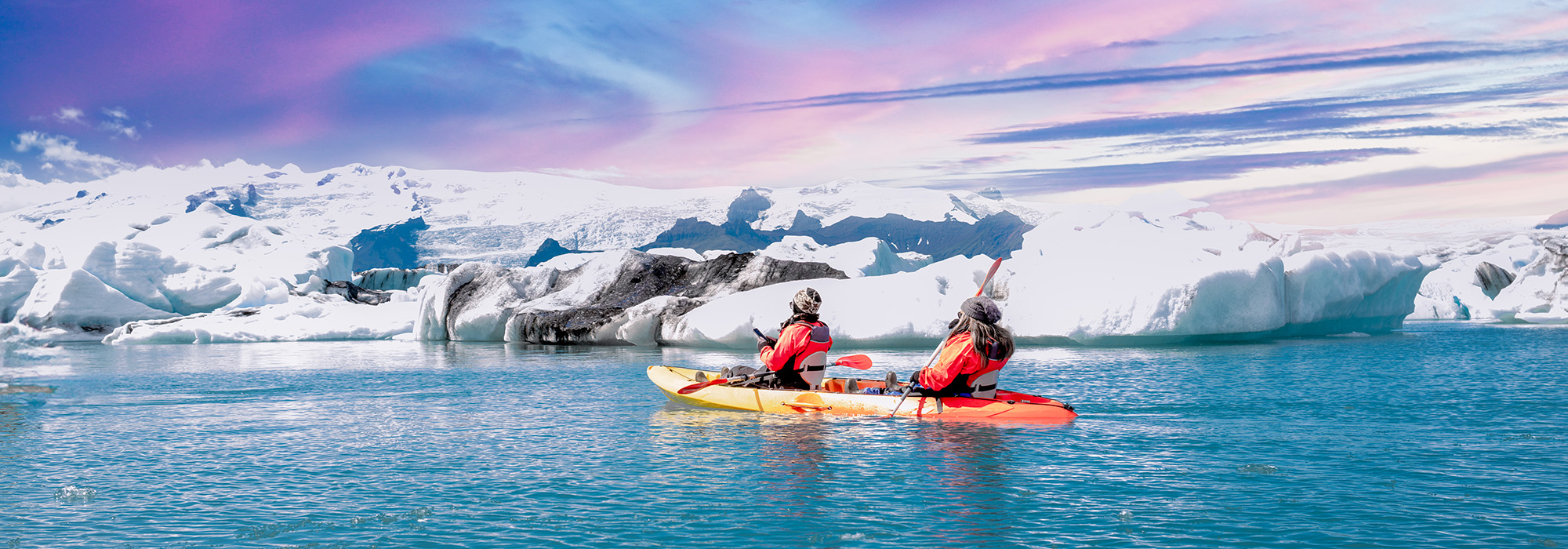 Kayaking beside an ice sheets near Iceland