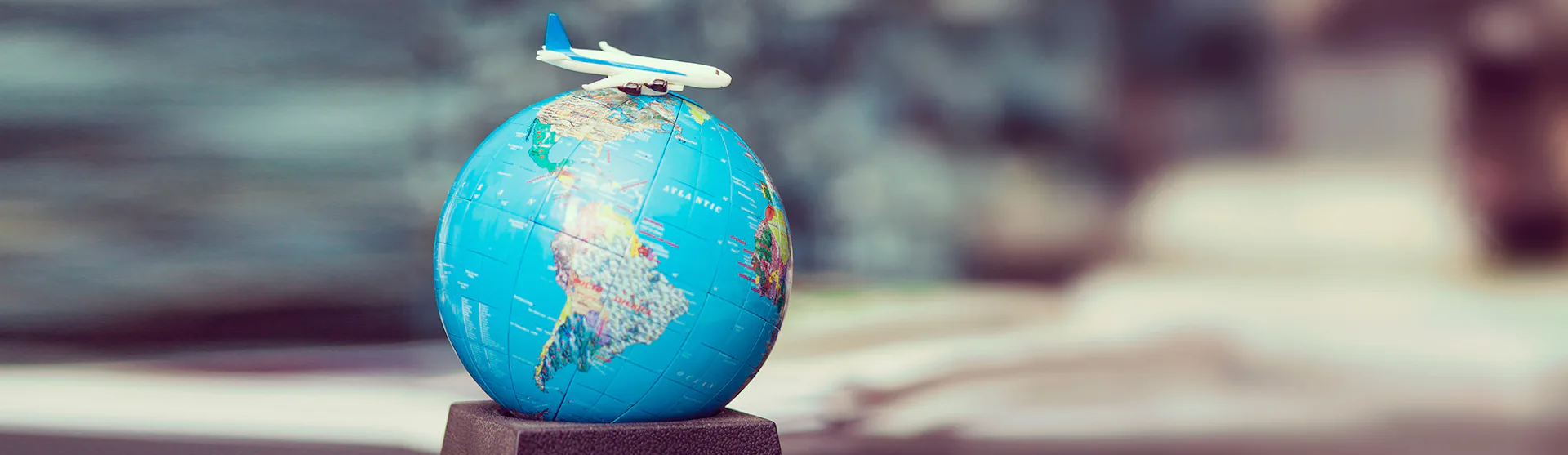 Plane atop a toy world globe - fly-cruises