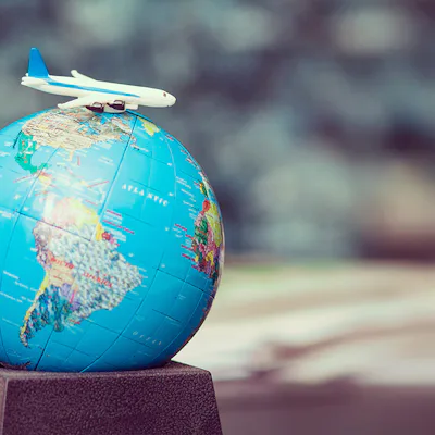 Plane atop a toy world globe