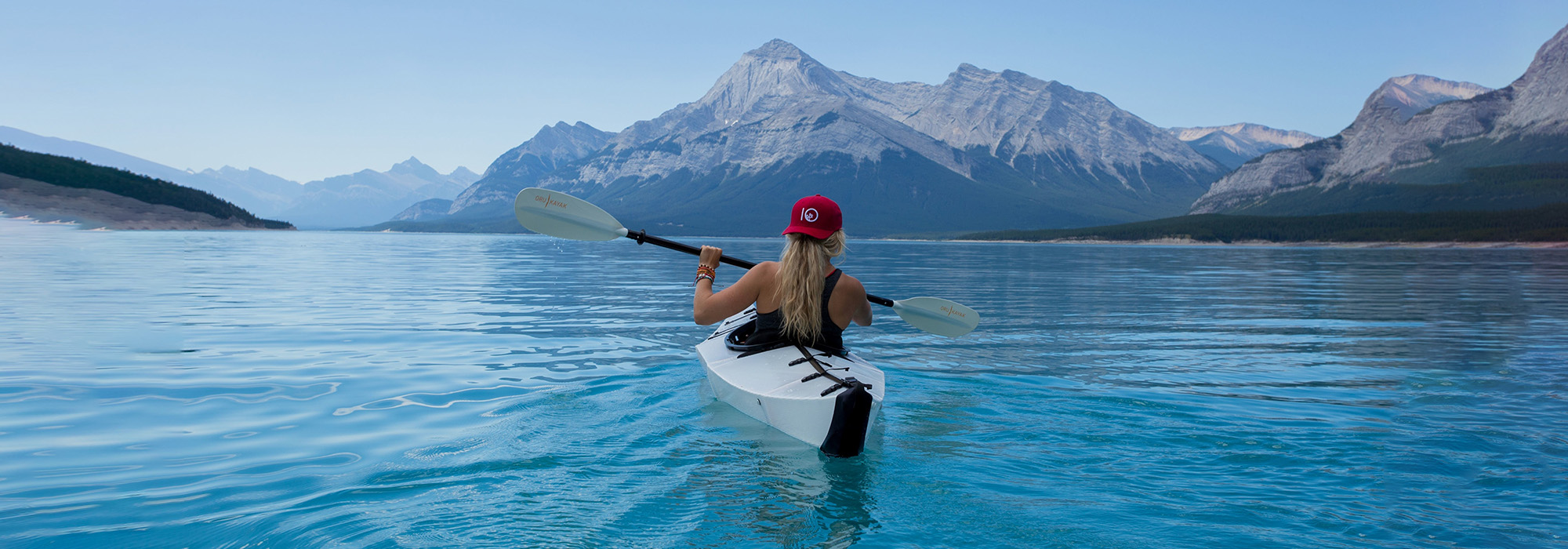 Woman kayaking surrounded by mountains