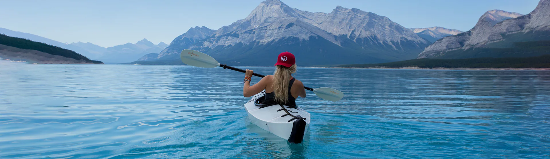 Woman kayaking surrounded by mountains
