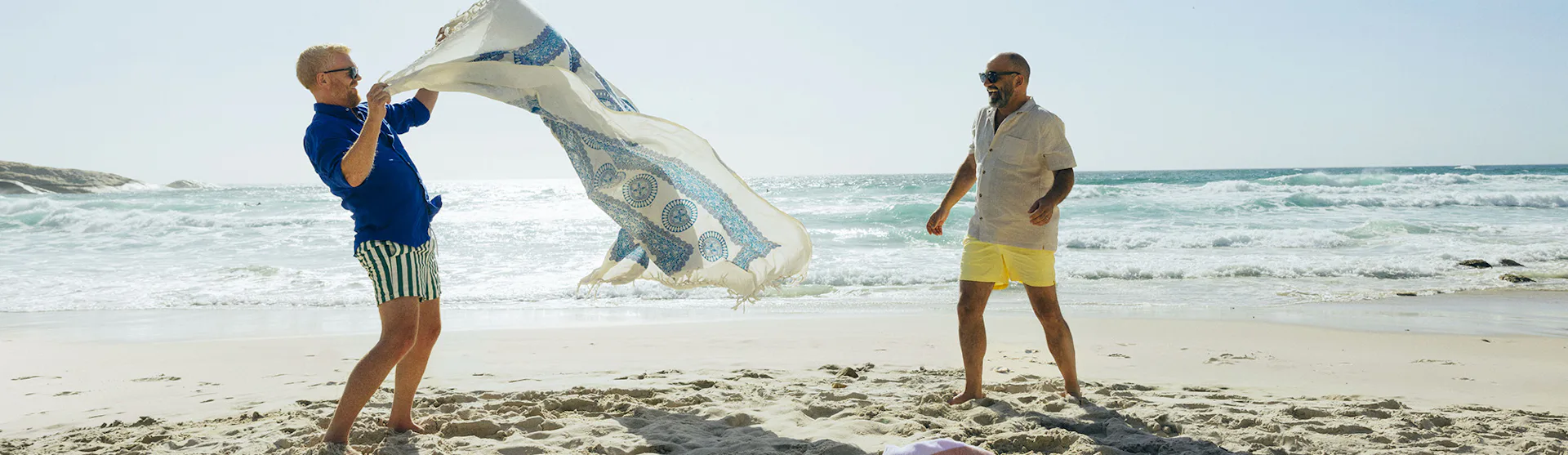 Two guys with a towel on the beach
