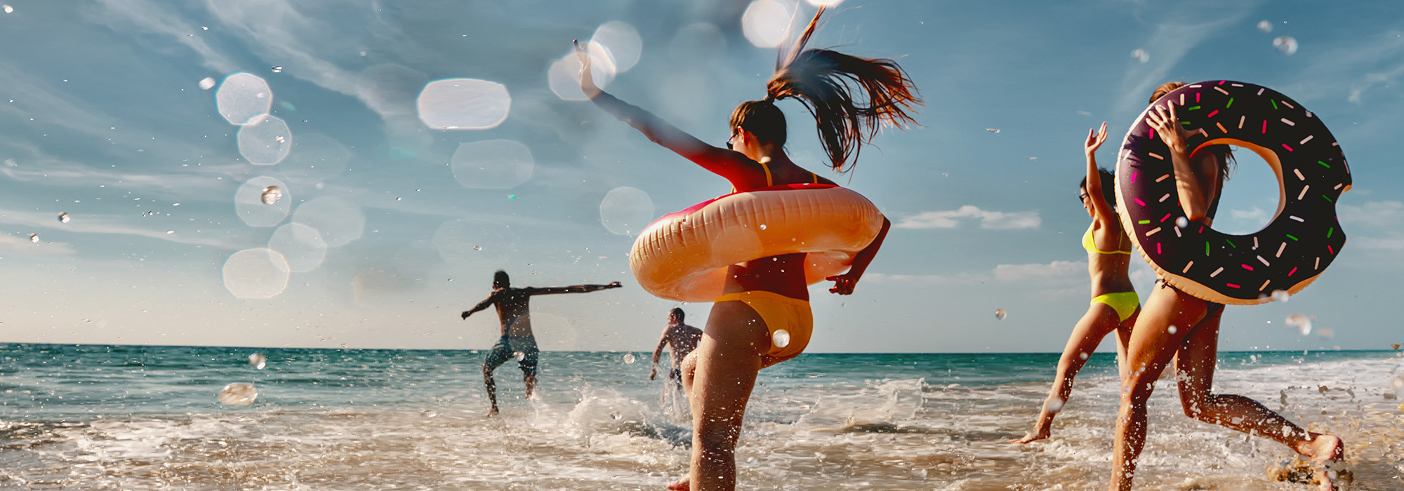 Group of friends at the beach with inflatable rings