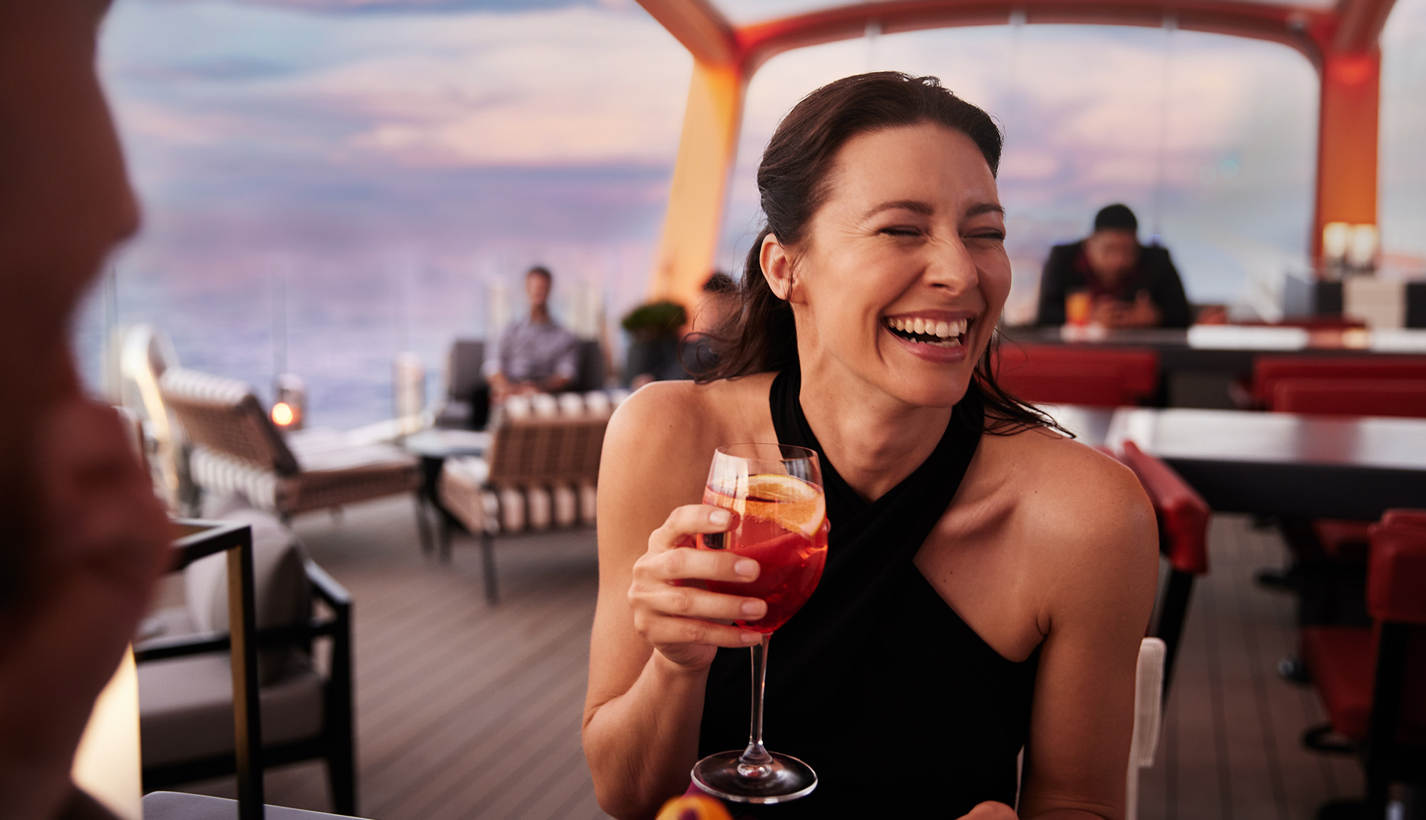 Celebrity Cruises - Woman drinking cocktail at the Magic Carpet