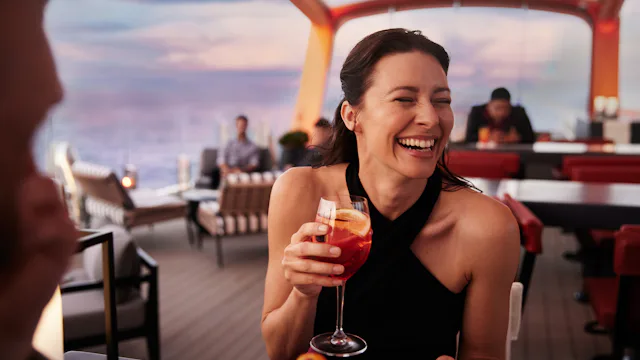 Celebrity Cruises - Woman drinking cocktail at the Magic Carpet