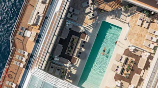 Man floating in the sunshine in EXPLORA pool